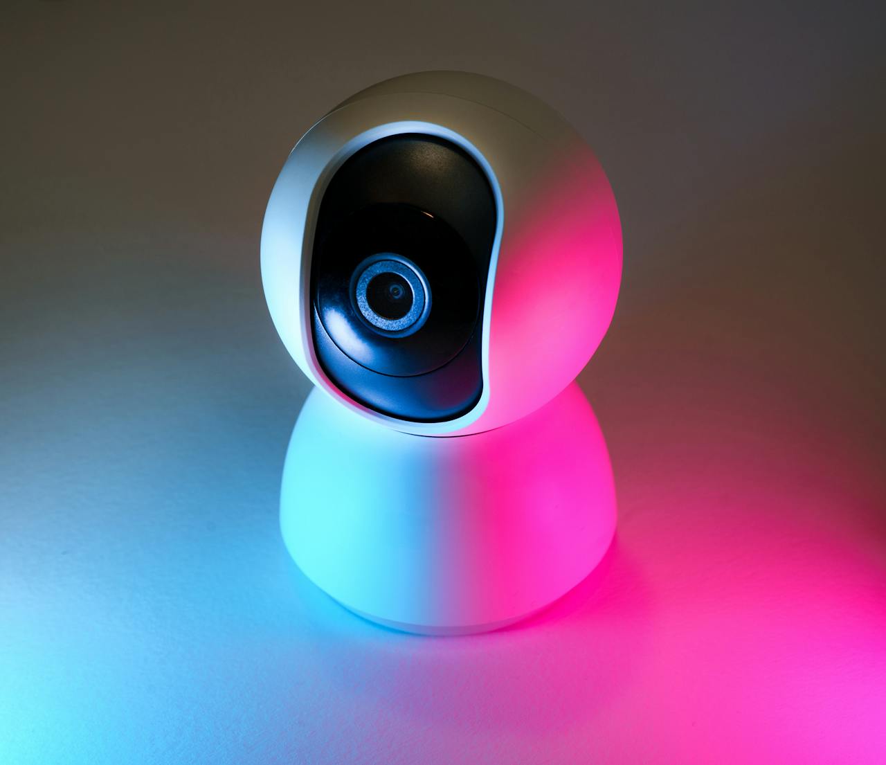 about-02 Stylish smart camera in vibrant blue and pink neon lighting, ideal for tech themes.
