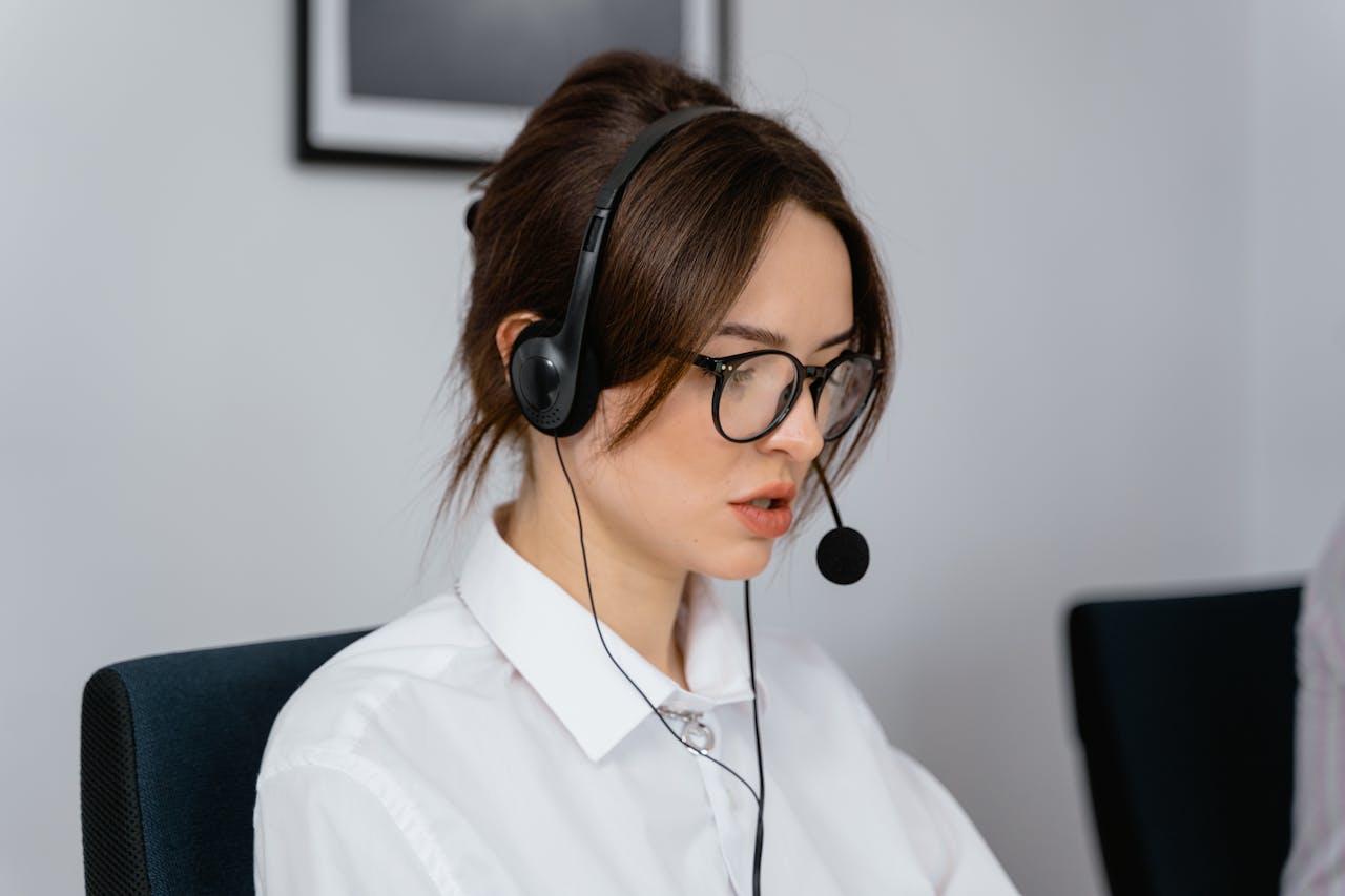 ours-journey Focused woman working in a call center with a headset, providing customer support and communication services.